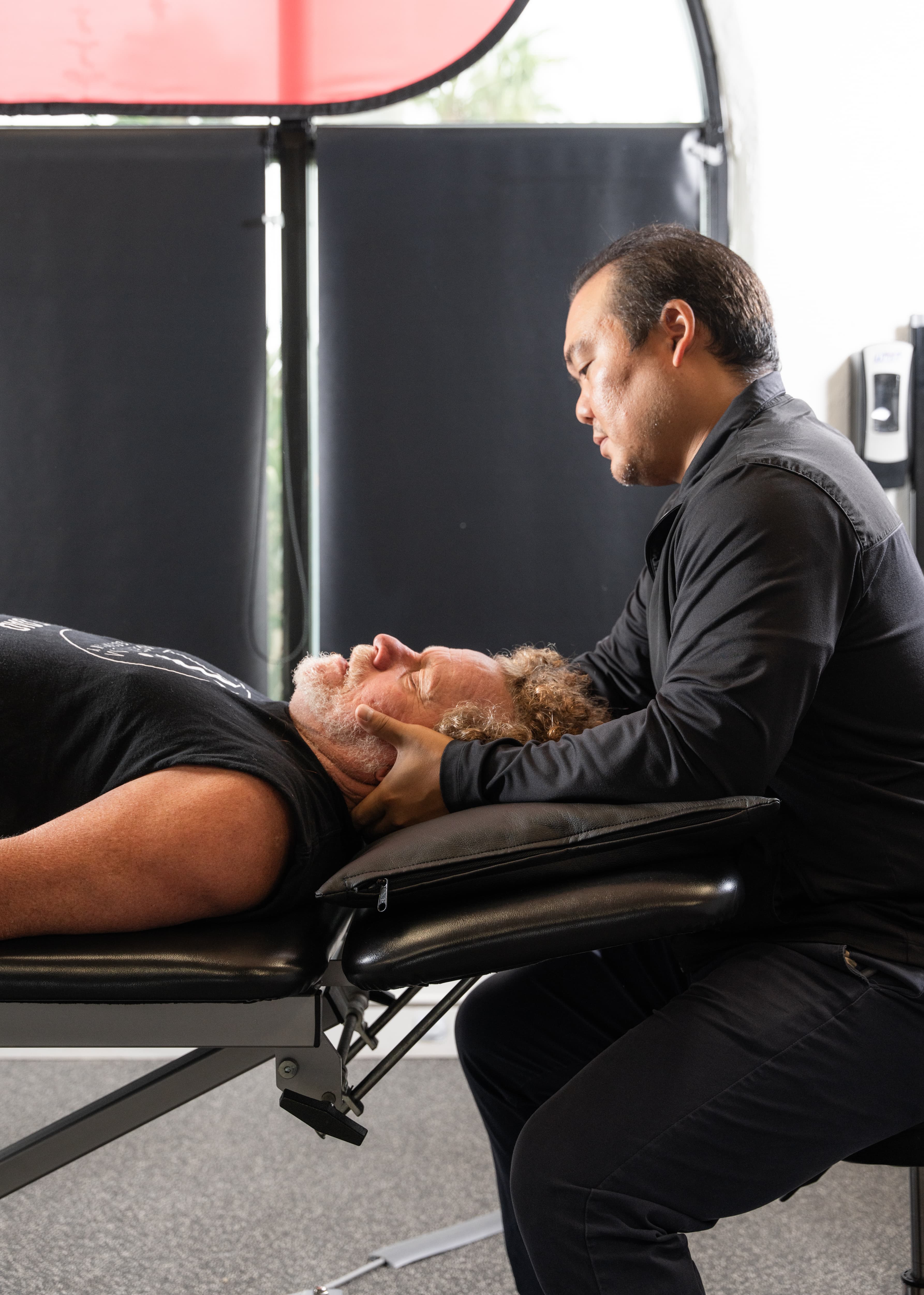 Member working with Dr. Jon Sakoda during a physical therapy session